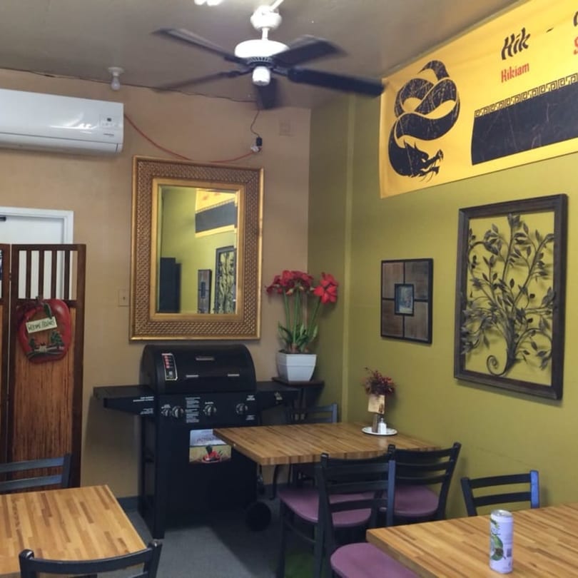 Interior of Lutong Bahay, a Filipino restaurant, with wooden tables, chairs, and a large mirror.