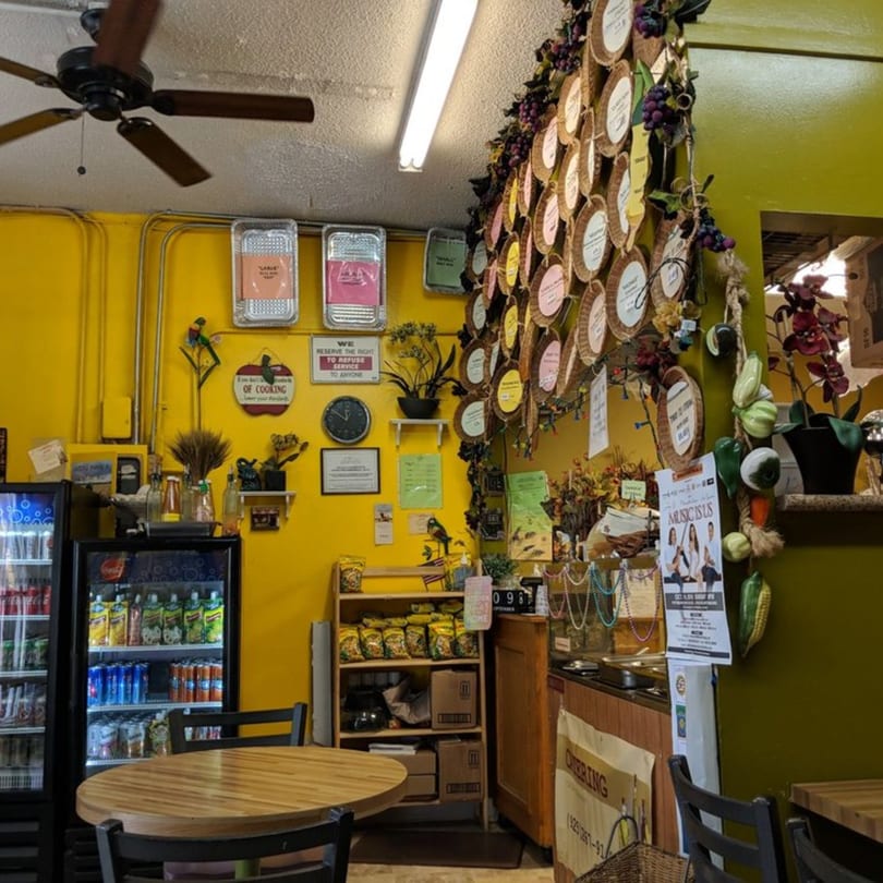 Interior of Lutong Bahay, a Filipino restaurant, with yellow walls, a ceiling fan, and various decorations.